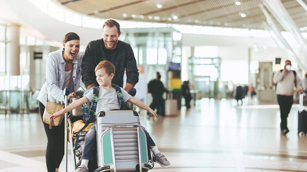 Happy parents tying their baby on a luggage cart