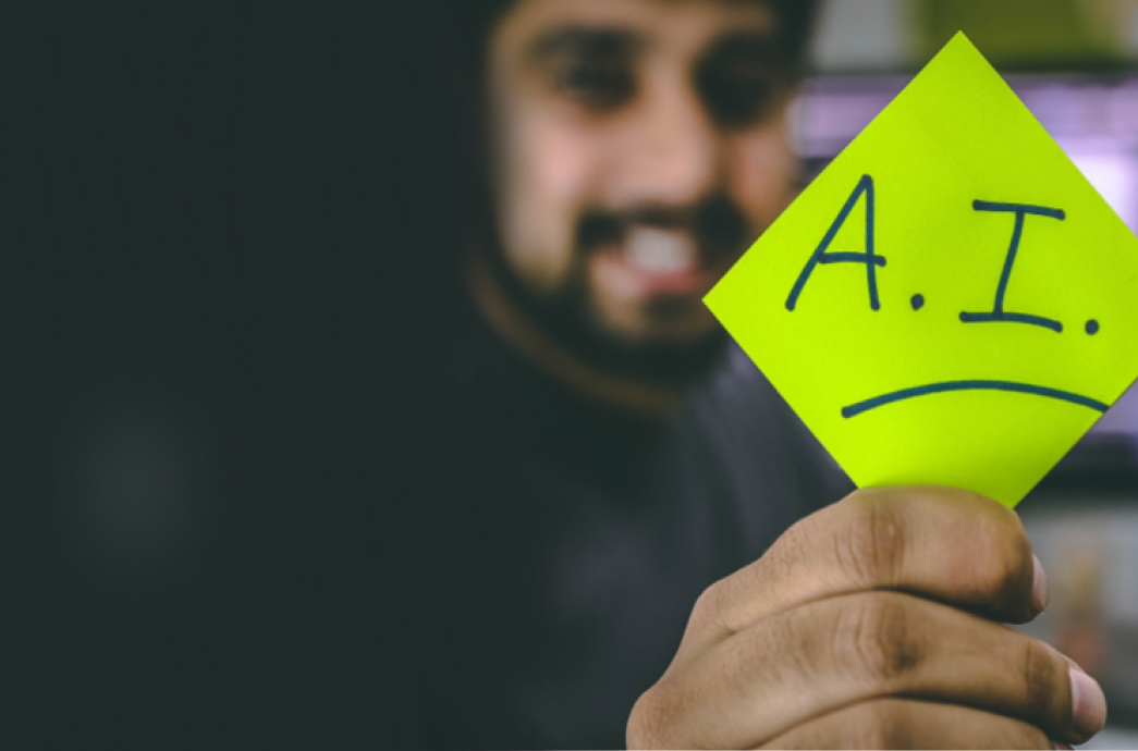 A man holding a sticky note with the words A.I.
