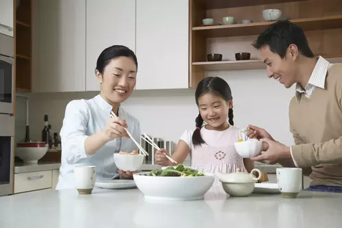 Happy family eating dinner at the table